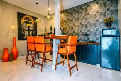 a kitchen with a table and orange chairs at Amshiga 5 in Jimbaran