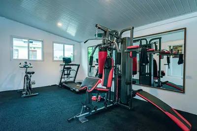 a gym with several tread machines and a mirror at Amshiga 5 in Jimbaran