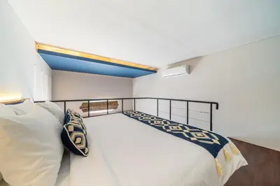 a bedroom with a large white bed with white pillows at First 5 Loft near Seminyak in Seminyak