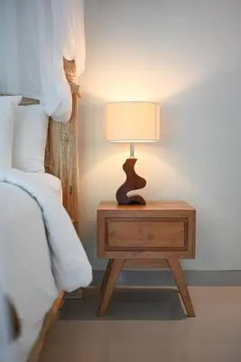 a table with a lamp on it next to a bed at Villa Laskmi Legian in Seminyak