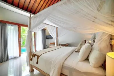 a bedroom with a white bed with a mosquito net at Villa Laskmi Legian in Seminyak