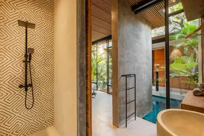 a bathroom with a tub and a wall with a door at Romantic Honeymoon Villa - Private Pool & Netflix in Dalung