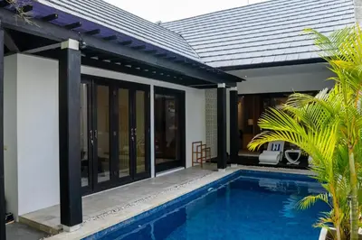 a house with a swimming pool in front of it at Jineng Febe G Villa in Seminyak