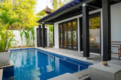 a swimming pool in front of a house at Jineng Febe G Villa in Seminyak