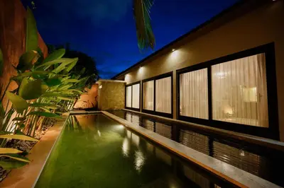 a house with a swimming pool in front of a building at Urban Villas 5BR in Legian