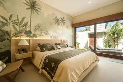 a bedroom with a large bed and a large window at Cozy Villa Alami 2BR Sanur beachside in Sanur