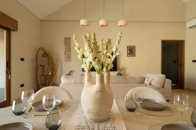 a vase with flowers on a table in a living room at Cozy Villa Alami 2BR Sanur beachside in Sanur