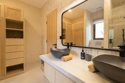a bathroom with a sink and a large mirror at Cozy Villa Alami 2BR Sanur beachside in Sanur