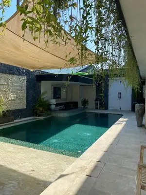 a swimming pool in a yard with a house at Luxury 3 BR Elegant intertior Perfect for group in Kerobokan