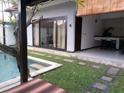 a house with a garden and a swimming pool at Rishi Villas in Kerobokan