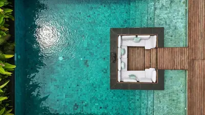 a view of a swimming pool with towels and water at Exclusive 4BR Villa Kito - Cinema, Sauna, Yoga and Pool in Jimbaran