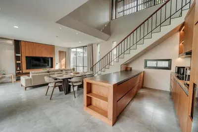 a living room with a staircase and a dining room at Natadesa Villa 3BR Family Villa in Jimbaran in Jimbaran