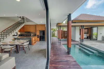 an open kitchen and dining room with a swimming pool in a house at Natadesa Villa 3BR Family Villa in Jimbaran in Jimbaran
