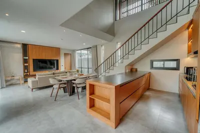 a living room with a staircase and a dining room at Natadesa Villa 3BR Family Villa in Jimbaran in Jimbaran