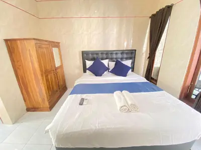 a bedroom with a bed with two slippers on it at SG Hotel - 2 Minutes to the Beach By Micky Studio 2 in Legian