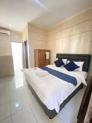 a bedroom with a large bed with blue pillows at SG Hotel - 2 Minutes to the Beach By Micky Studio 2 in Legian