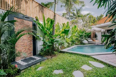 a backyard with a swimming pool and a house at Stylish 3BR Villa in Central Berawa Canggu - near Finns in Canggu