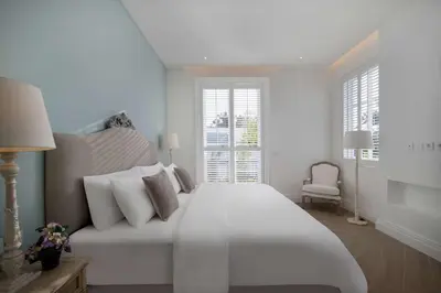 a white bedroom with a large bed and a window at Colonial House 4BR Villa Ocean View in Berawa in Canggu