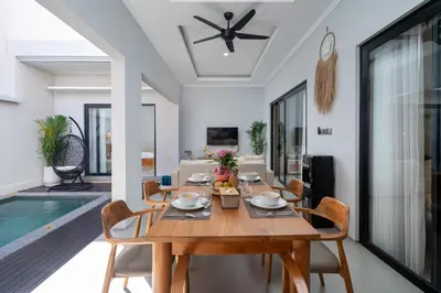 a dining room with a wooden table and chairs at Villa Bella Poppy in Seminyak