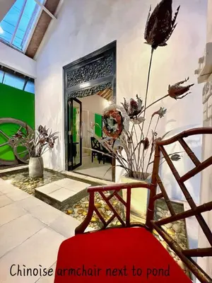 a living room with a red chair and a fireplace at Villa Anh Yeu - 6 BR in Central Seminyak with Huge Pool & Garden in Seminyak