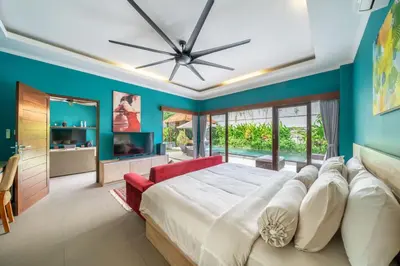 a bedroom with a large bed and a red chair at Villa Sunset-Near Seminyak Pool Free Airport Xfer in Seminyak