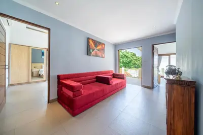 a living room with a red couch in a room at Villa Sunset-Near Seminyak Pool Free Airport Xfer in Seminyak