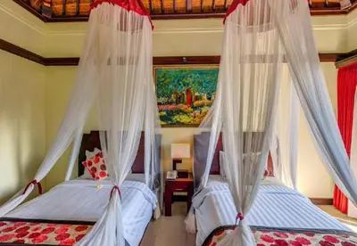 a bedroom with two beds with mosquito nets at Exquisite 3 BR Villa Seminyak CYN in Seminyak
