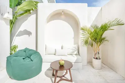 a living room with a green chair and a table at Villa Arya 1 in Kerobokan