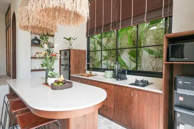 a kitchen with a large window and a kitchen island at Villa Arya 1 in Kerobokan