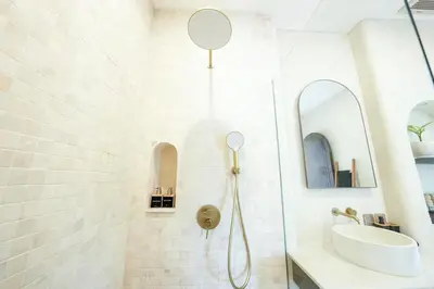 a white bathroom with a shower and a sink at Villa Arya 2 in Kerobokan