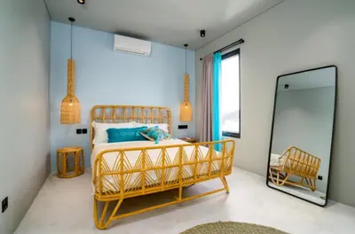 a bedroom with a bed and a mirror at Villa Javel in Seminyak