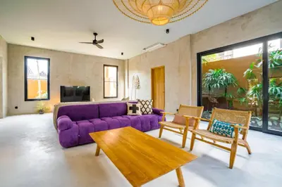 a living room with a purple couch and a table at Villa Javel in Seminyak