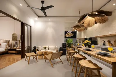 a kitchen and living room with a bar and chairs at Gorgeous 6 beds, 14 pax in the heart of Seminyak in Seminyak