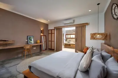 a bedroom with a bed and a desk and a clock at Gorgeous 6 beds, 14 pax in the heart of Seminyak in Seminyak