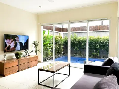 a living room with a large window and a tv at 3BR, 5Beds, 10ppl, Seminyak, BeachSide in Seminyak