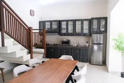 a kitchen with a wooden table and a stainless steel refrigerator at 3BR, 5Beds, 10ppl, Seminyak, BeachSide in Seminyak