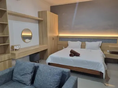 a hotel room with a bed and a couch at The Sania's in Seminyak