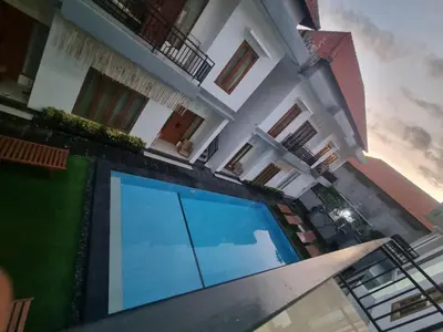 a house with a large swimming pool in front of it at The Sania's in Seminyak
