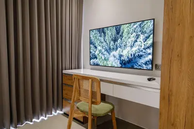 a television sitting on a desk with a chair at Forseti Athena Managed by ARM One Hundred in Seminyak