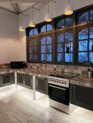a kitchen with a stove and some windows at Cozy villa 777 near canggu 3BR in Kerobokan