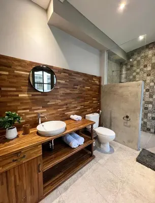 a bathroom with a sink and a toilet and a mirror at Cozy villa 777 near canggu 3BR in Kerobokan