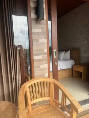 a room with a bed and a table and a chair at Brekele Berawa Beachhouse in Canggu