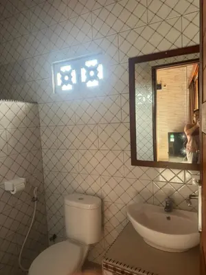 a bathroom with a toilet and a sink and a mirror at Brekele Berawa Beachhouse in Canggu
