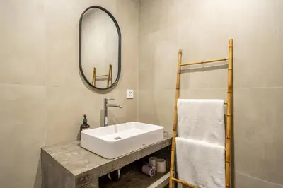 a bathroom with a white sink and a mirror at Nyma 2BR Villa Seminyak in Seminyak