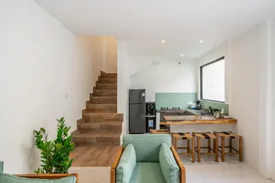 a living room with a staircase and a kitchen at Nyma 2BR Villa Seminyak in Seminyak