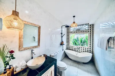 a bathroom with a sink and a tub and a toilet at Villa Kensington in Seminyak