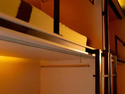 ajar door in a room with a shelf and a closet at Kuta Cube Hostel in Kuta