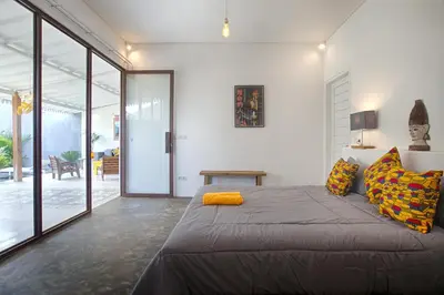 a bedroom with a large bed with yellow pillows at Villa Mertanadi - Cosy 2bdrs in center Kerobokan - popular district in Seminyak