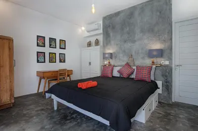 a bedroom with a large bed with red pillows at Villa Mertanadi - Cosy 2bdrs in center Kerobokan - popular district in Seminyak