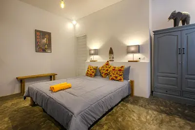 a bedroom with a large bed with yellow pillows at Villa Mertanadi - Cosy 2bdrs in center Kerobokan - popular district in Seminyak